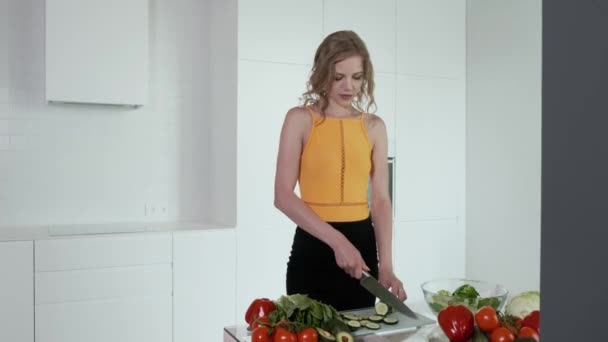 Jonge Vrouw Snijdt Komkommer Voor Groentesalade Witte Moderne Keuken Groenten — Stockvideo
