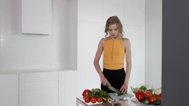 Jonge Vrouw Snijdt Komkommer Voor Groentesalade Witte Moderne Keuken Groenten — Stockvideo