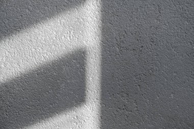 Gölge ve ışık panjurlu duvardaki pencereleri aydınlatıyor. Soyut bir sabah ışığı ve duvardaki gölge..