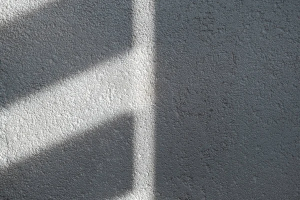 Shadow and light through blinds window on tiled wall. Abstract form morning light and shadow on the wall.