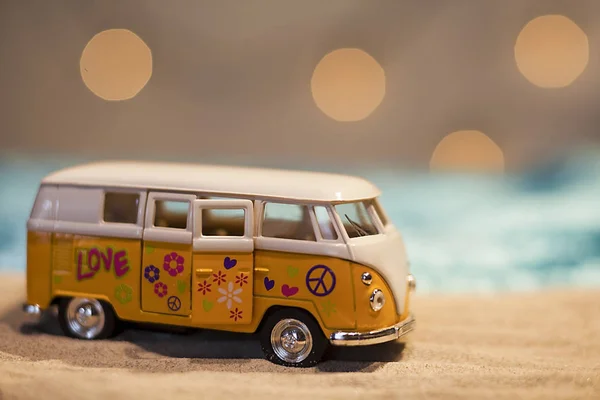 Yellow hippie van with peace sign on a sandy beach
