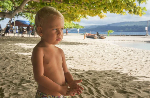 Bebek Plajda dinleniyor. Çocuk mesafe içine düşünceli görünüyor. güneşli yaz gün.