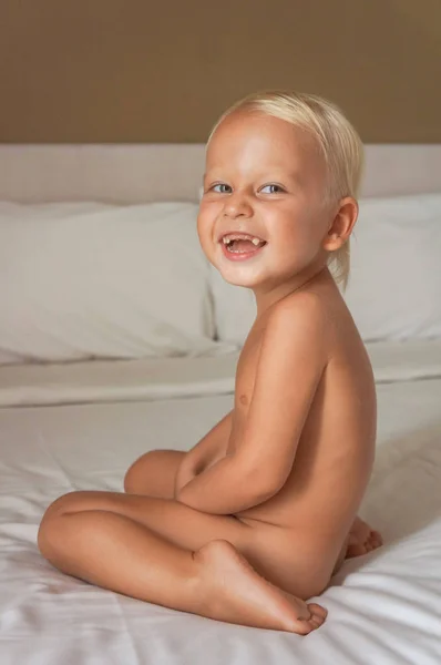 Niño Sienta Cama Ríe Niño Sonríe Vista Lateral Cuerpo —  Fotos de Stock