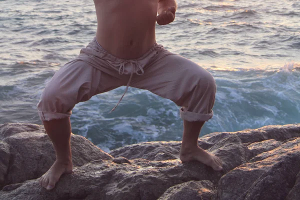 Hombre de pie en árbol de yoga posan en la playa del océano al atardecer —  Fotos de Stock