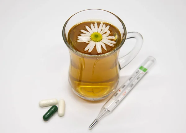 Травяной чай в прозрачной чашке, термометре и белых таблетках . — стоковое фото