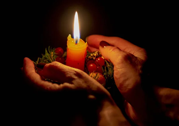 Vela de Natal ardente com decoração nas mãos das mulheres — Fotografia de Stock