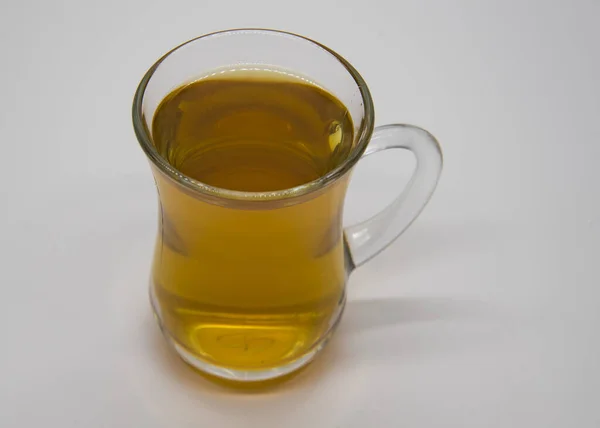 Прозрачная чашка с напитком на сером фоне . — стоковое фото