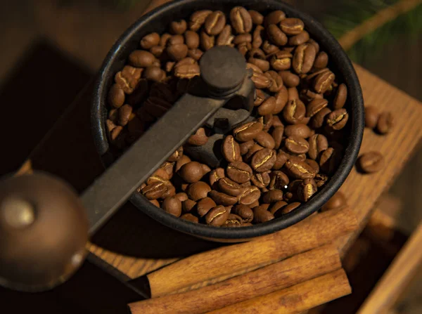 Hand grinder with coffee beans, top view close-up.