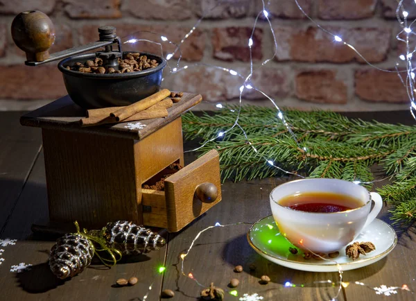 Старая ручная кофемолка и фарфоровая чашка против кирпичной стены. Новый год в мансарде . — стоковое фото