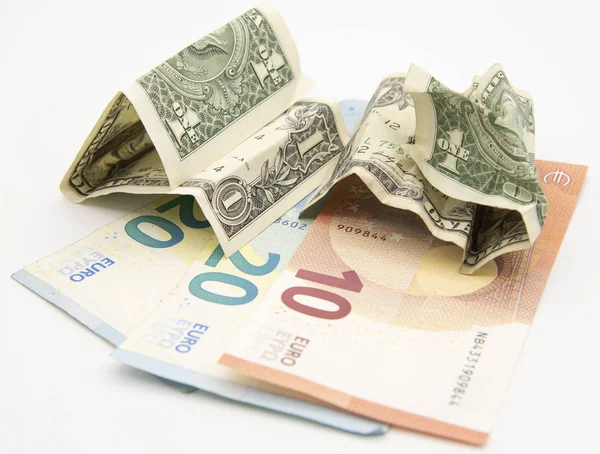 Несколько евро купюр и два смятых доллара на легком фоне . — стоковое фото