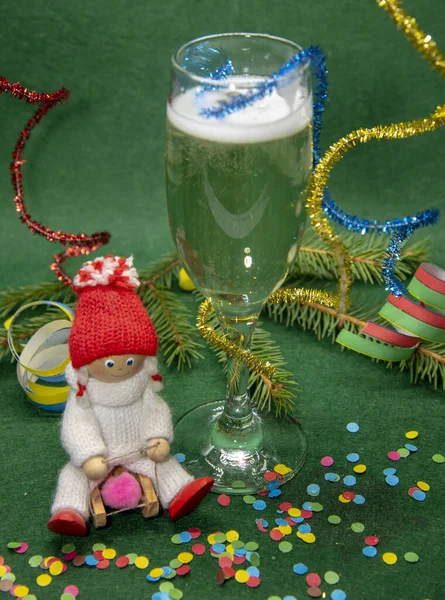 Figuur van een meisje op een slee, een glas champagne en kerstversieringen — Stockfoto