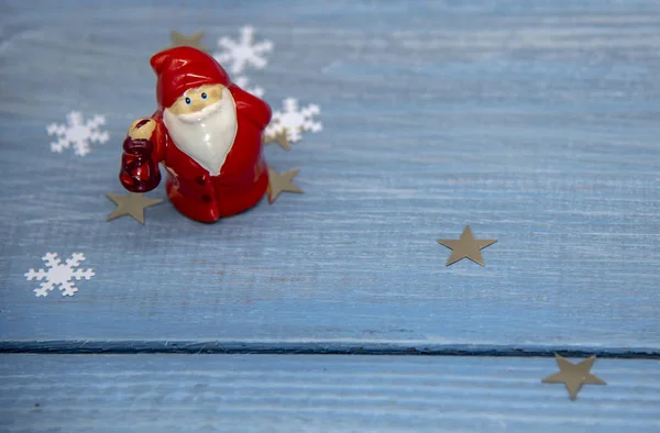 Beeldje van de Kerstman op een blauwe houten achtergrond. — Stockfoto