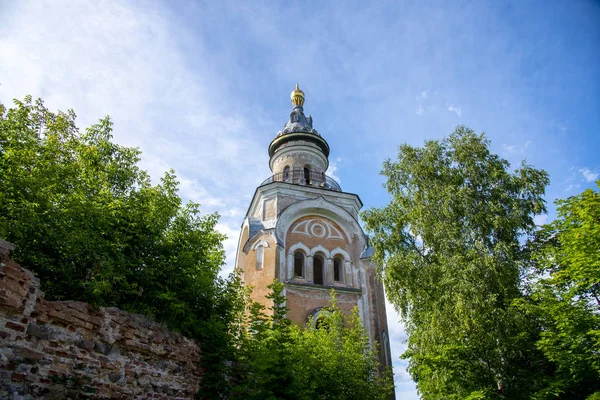 A tall tower against a blue sky, surrounded by green trees. — Stock Photo, Image