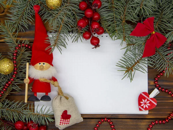 Sobre un fondo de madera, una hoja blanca de papel a su alrededor Decoración de Navidad . — Foto de Stock