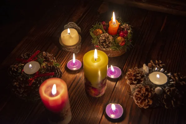 Molte candele accese al buio su un tavolo di legno . — Foto Stock