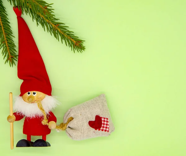 Fir takken en kerstboom speelgoed Kerstman op een delicate groene achtergrond. — Stockfoto