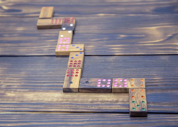 Playing dominoes on a wooden textured table.