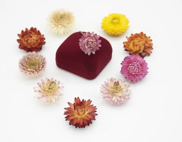 Una caja de regalo para joyas y flores secas dispuestas en forma de corazón . — Foto de Stock