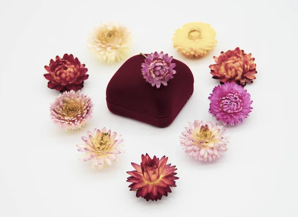 Una caja de regalo para joyas y flores secas dispuestas en forma de corazón . — Foto de Stock