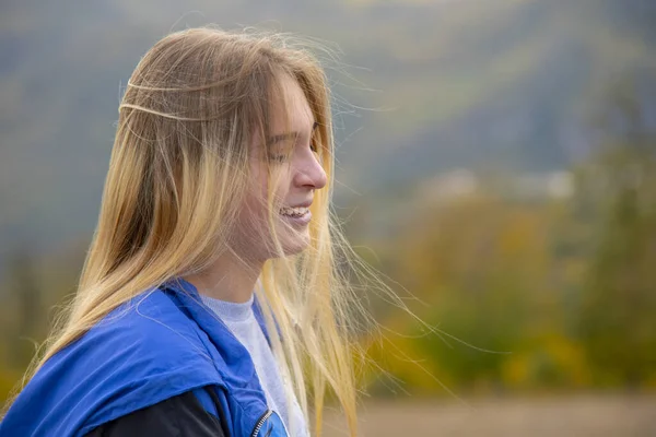 Portret van een lachend meisje met blond haar. — Stockfoto