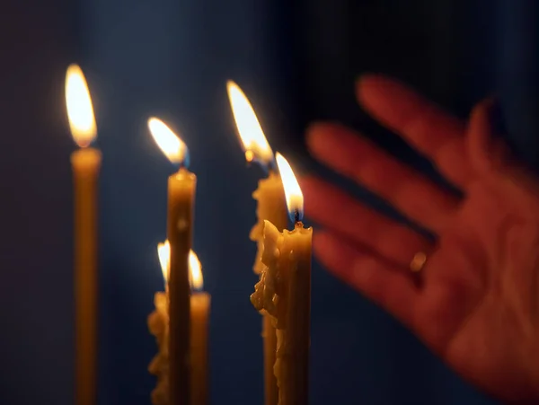 Brinner i det dunkla ljuset av ljus i den kristna kyrkan. — Stockfoto