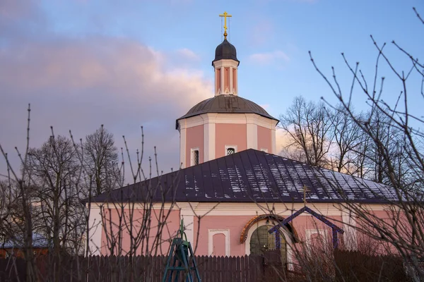 En rosa kyrka mot en klarblå molnig himmel. — Stockfoto