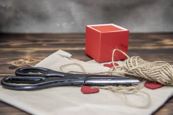 Scissors, coarse thread, and a gift box lie on Kraft paper — Stock Photo, Image