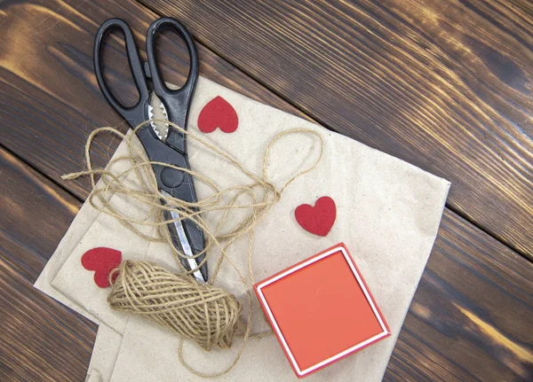 Scissors, coarse thread, and a gift box lie on Kraft paper — 스톡 사진