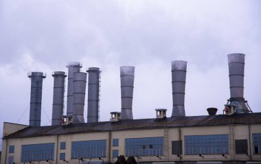 Gri gökyüzüne doğru yükselen buharlı borular..