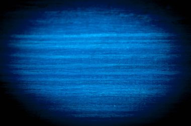 A bright blue oval in a black vignette.