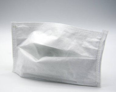 Beyaz arka planda tek kullanımlık beyaz tıbbi maske. Enfeksiyona karşı önleyici tedbirler