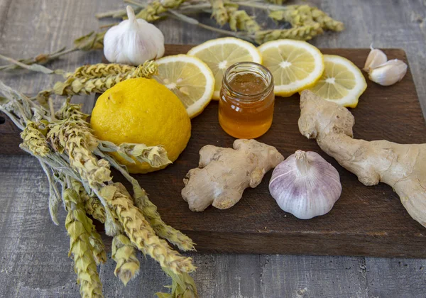 Ginger, lemon, garlic and mountain Mursal tea on a rough wooden Board. Alternative medicine.