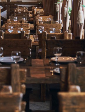 Restoranın salonunda ziyaretçi yok. Masaları misafirler için hazırla. .