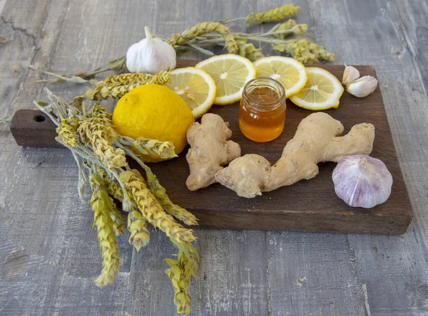 Gingembre, citron, ail et thé de Mursal de montagne sur une planche de bois rugueuse . — Photo