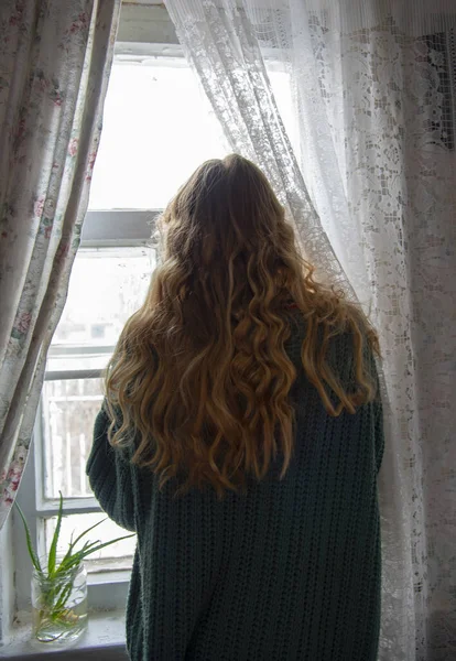 Uma Menina Com Longos Cabelos Loiros Ondulados Fica Uma Janela — Fotografia de Stock