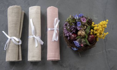 Paskalya kompozisyonu bıldırcın yumurtası ve keten peçete yuvası, sarılmış ve kurdeleyle bağlanmış. Metin ve tasarım için boşluk kopyala.