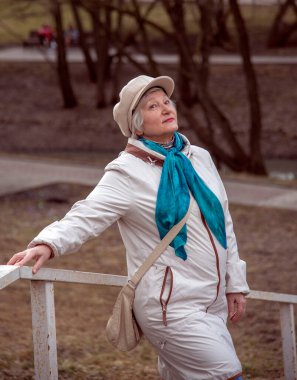 Parkta yürüyüş yapan bereli, yaşlı, zarif bir kadın.. 