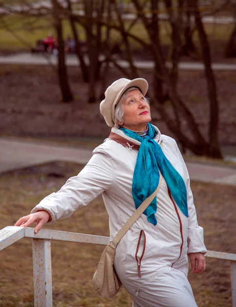 An elderly elegant woman in a beret on a walk in the Park. — Stock Photo, Image