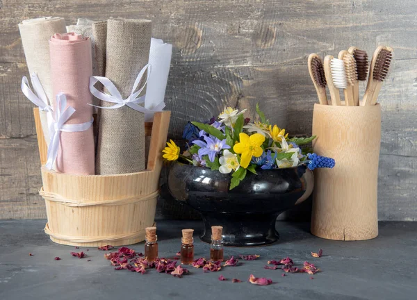 Accessories made of eco-friendly materials for the bathroom and skin care.A set of toothbrushes , linen towels and flowers in a ceramic vase for a good mood.