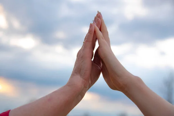 Hand Elderly Woman Hand Teenage Girl Background Cloudy Sky — Stock Photo, Image