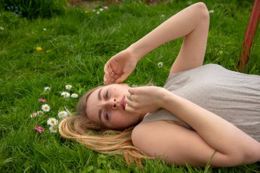 Parlak yeşil çimlerde dinlenen kız.