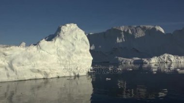 Ilulissat Grönland köy alanında batan güneşin ışınları tarafından aydınlatılmış büyük bir buzul boyunca yelken