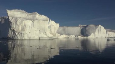 Ilulissat Grönland köy alanında batan güneşin ışınları tarafından aydınlatılmış büyük bir buzul boyunca yelken