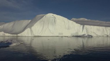 Ilulissat Grönland köy alanında batan güneşin ışınları tarafından aydınlatılmış büyük bir buzul boyunca yelken