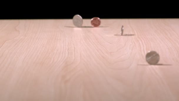 Slow motion munten spinnen op tafel — Stockvideo