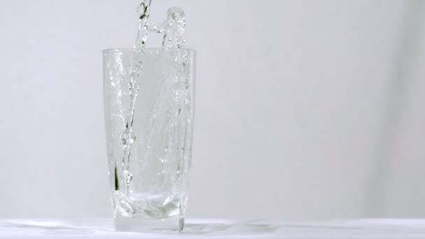 Gaseosa transparente de botella a vidrio en cámara lenta — Vídeo de stock