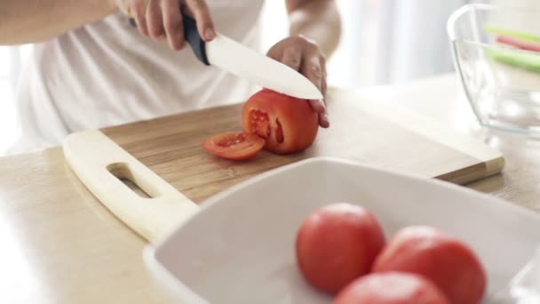 Mulher cortando tomate na tábua de corte na cozinha câmera lenta — Vídeo de Stock