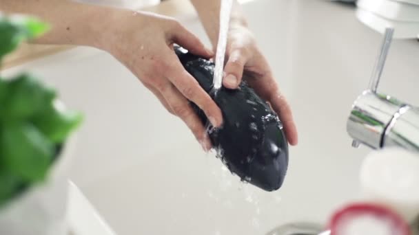 Donna lavaggio melanzane sotto acqua di rubinetto rallentatore — Video Stock
