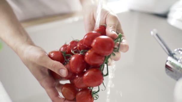 Vrouw van cherry tomaten onder leidingwater slowmotion wassen — Stockvideo