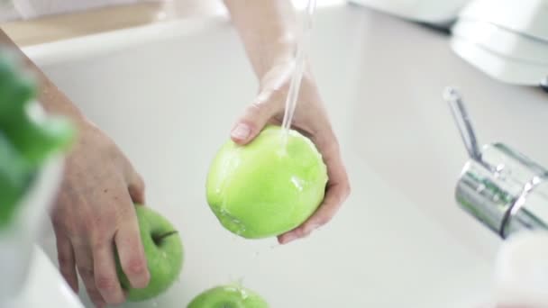 Mujer lavado verde manzana bajo agua del grifo cámara lenta — Vídeos de Stock